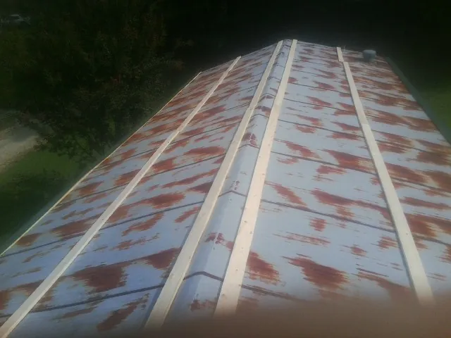 Rusted metal roof panels with new wood purlins before replacement — Storm Damage Roof Repair in Coupland by Roofing Brothers