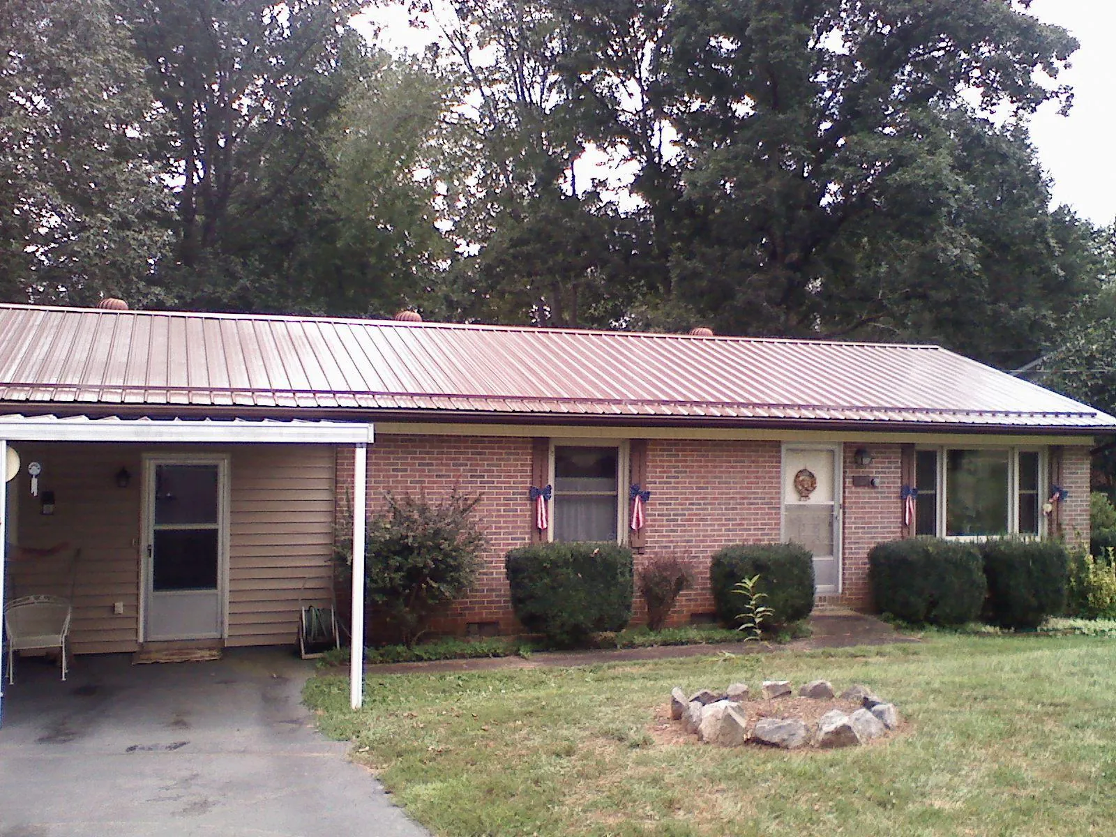 Bronze metal roof and carport on a brick ranch home — Roof Repair work by our crew in Coupland